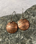 Rustic copper discs cross hatch pattern
