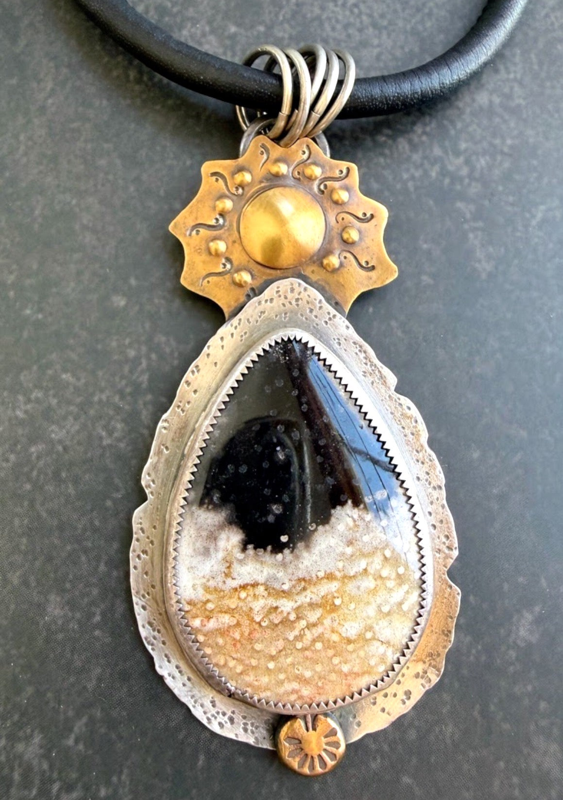 Petrified Palmwood in silver with bronze sun